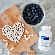 Pure Encapsulations supplement bottle beside a folded receipt on a wooden table in natural light