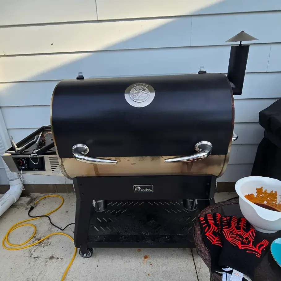 Close-up of the Recteq RT-1600 stainless steel body and distinctive horn handles on a backyard patio