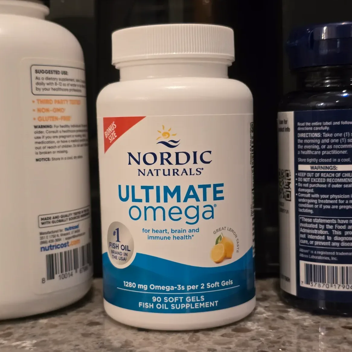 Nordic Naturals Ultimate Omega bottle standing upright on a rustic wooden surface with soft side lighting