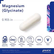 Magnesium glycinate supplement bottle on a wooden nightstand with a glass of water and dim lamp