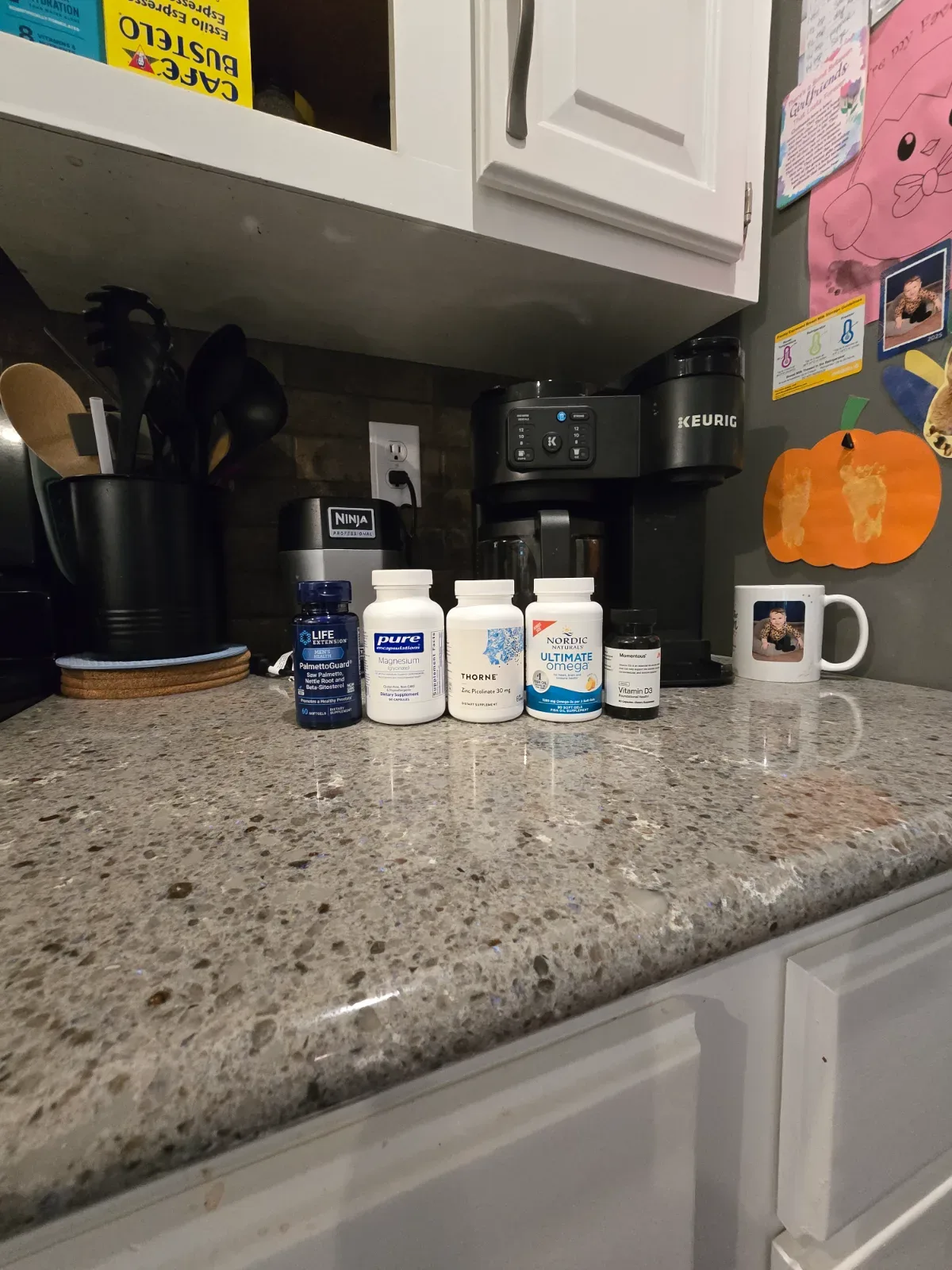 Momentous D3 bottle alongside other supplement bottles in a morning stack on a wooden surface.