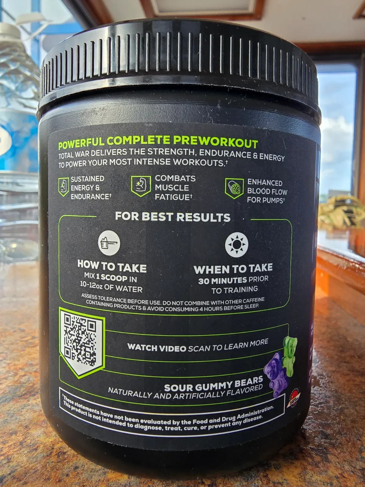 Shaker bottle standing next to a pre-workout supplement tub on a counter