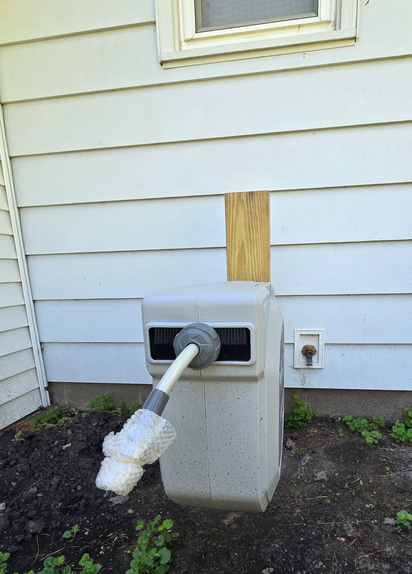Hozereel retractable garden hose reel mounted on exterior house wall with connection hardware visible