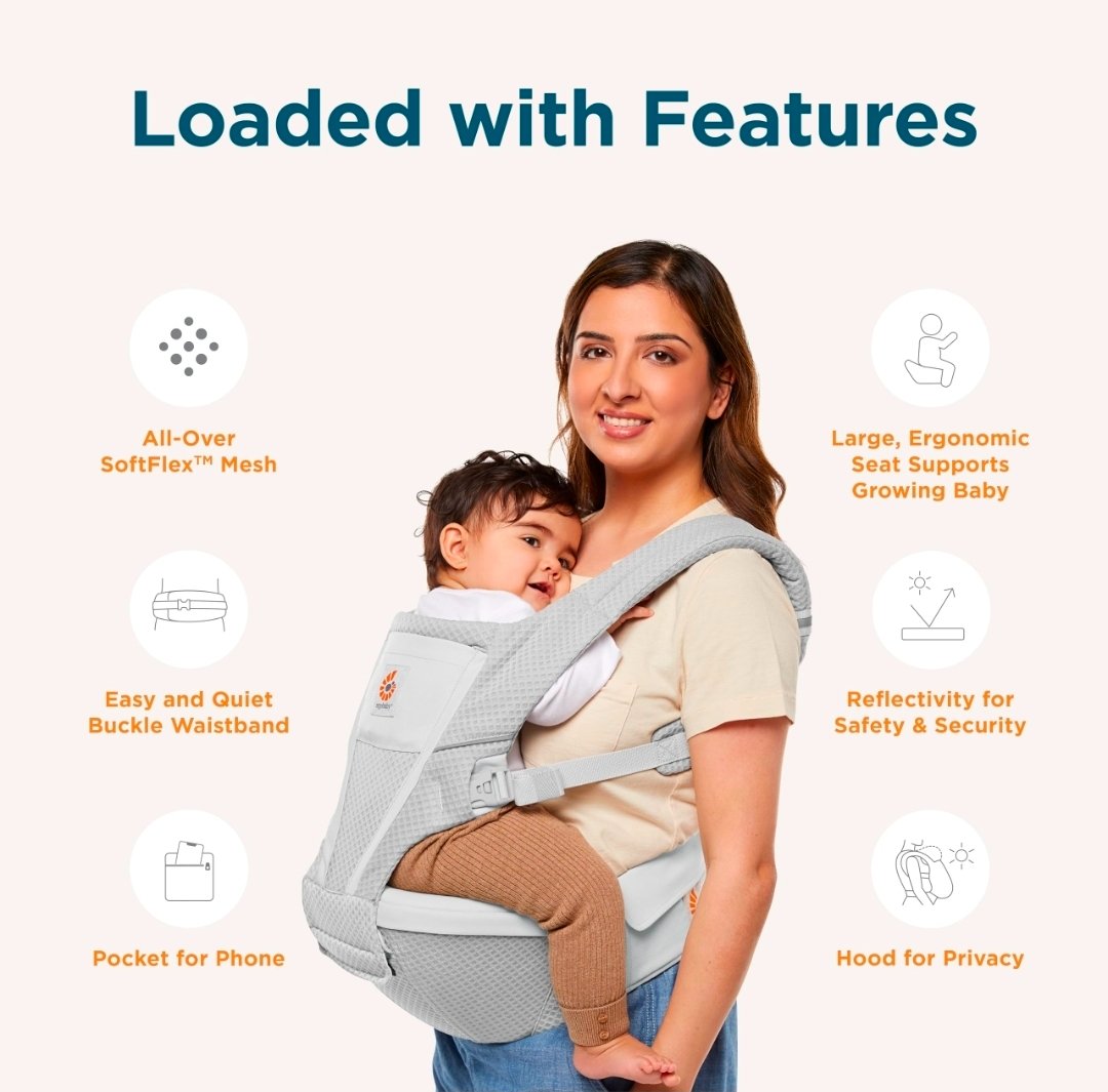 Ergobaby Alta Hip Seat Baby Carrier hanging on a hook near a front door with a diaper bag nearby